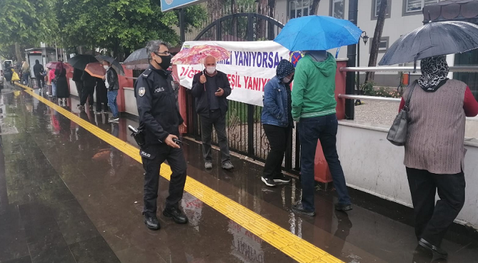 PTT önünde yağmur altında maaş kuyruğu