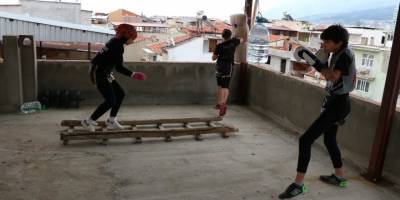 Muay Thai sporcusu kardeşler pet şişe ve yastıkla antrenmanlarını sürdürüyor