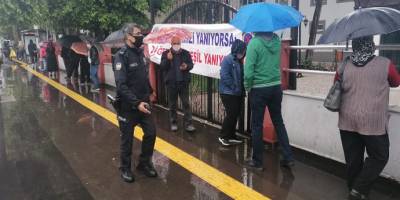 PTT önünde yağmur altında maaş kuyruğu